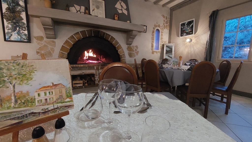 salle du restaurant Auberge du Moulin avec sa cheminée pendant la saison hivernale